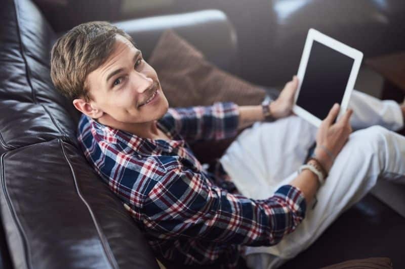 hombre sonriendo sosteniendo una tablet