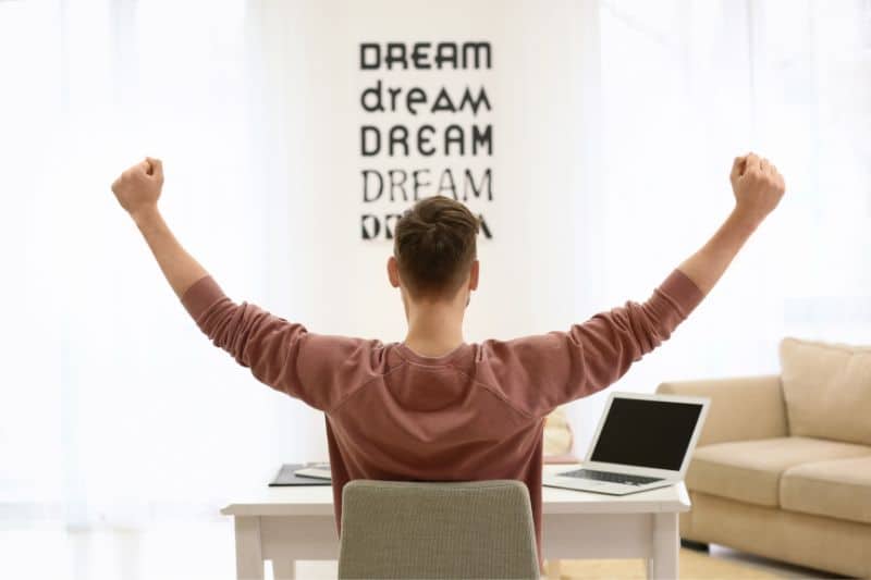 Worker on his back in office raising his arms